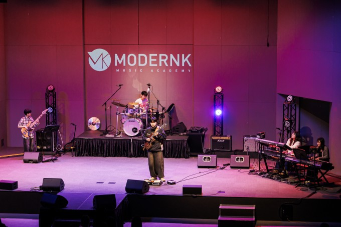 Modern K students playing instruments on stage